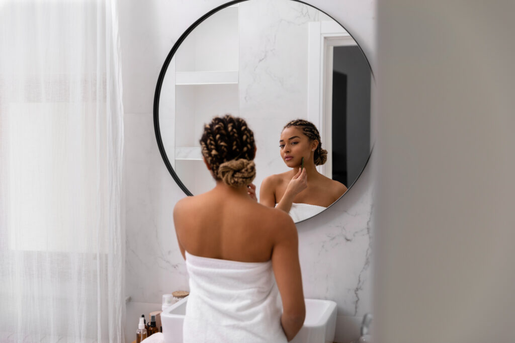 A young woman looking at her reflection after visiting Medical Grade Aesthetics for AviClear near Janesville.
