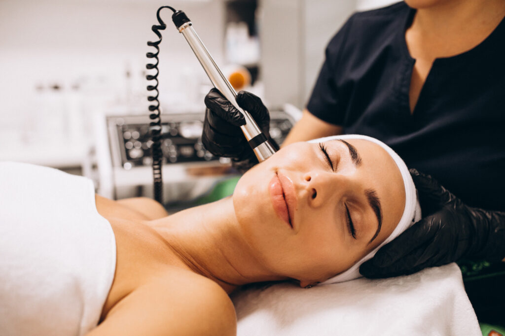 A woman laying down on a comfortable treatment table at Medical Grade Aesthetics while she receives one of the many options for medical grade facials near Janesville.