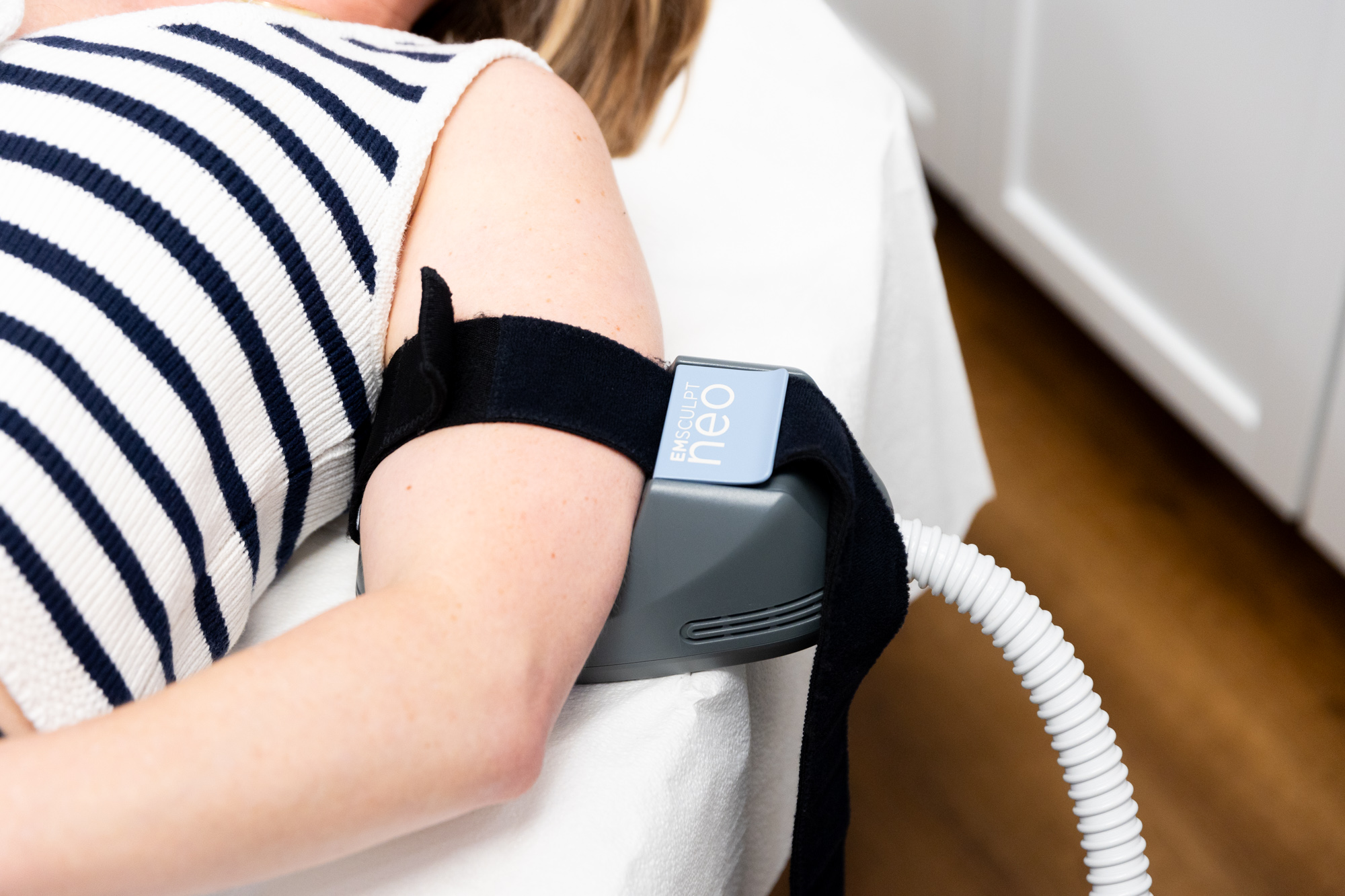 A patient undergoes Emsculpt NEO treatment on her upper arms as part of her plan for body contouring near Janesville.