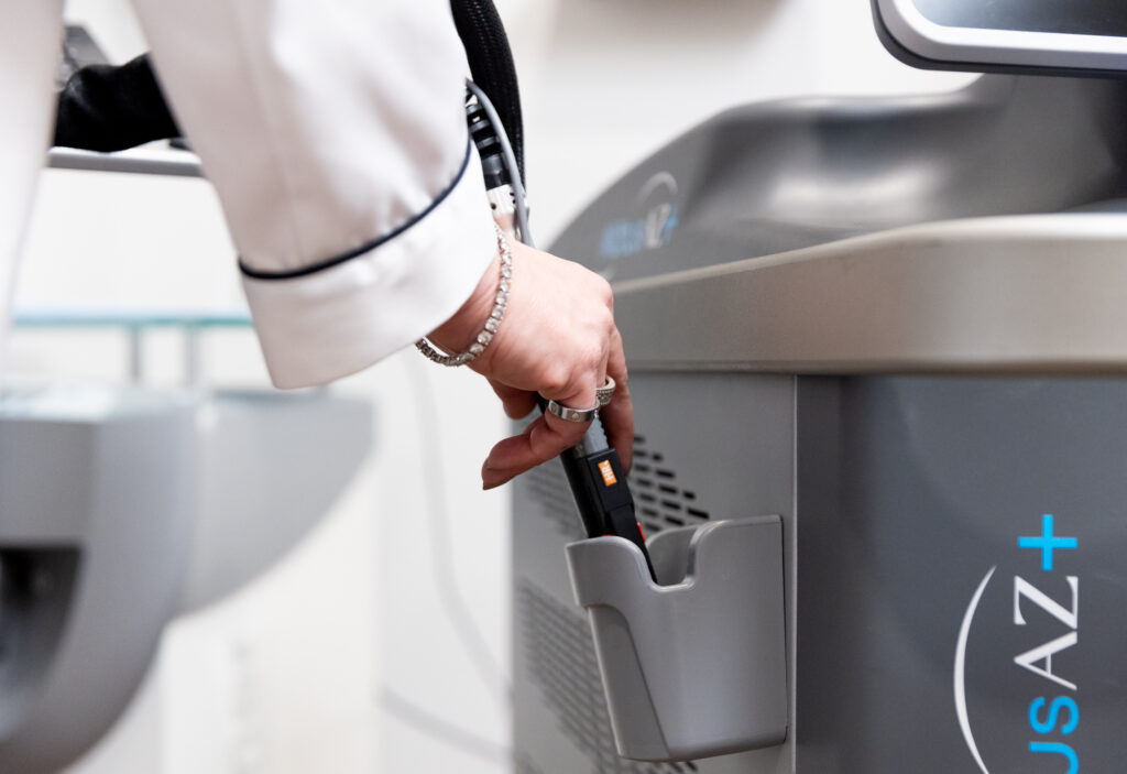 A medical professional reaches for the Motus AZ+ laser device to provide laser hair removal near Freeport.