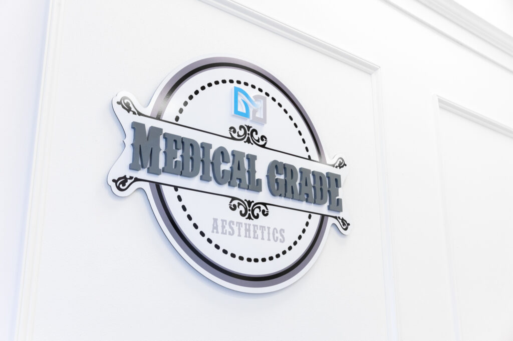 The logo of Medical Grade Aesthetics hangs on a door at their practice, where they offer CO2 laser resurfacing near Janesville.